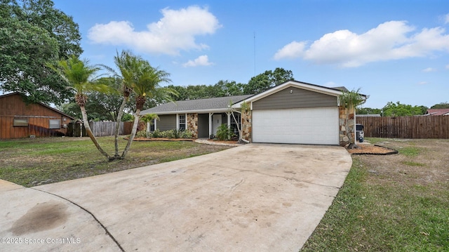 ranch-style home with fence, a front yard, stone siding, concrete driveway, and an attached garage