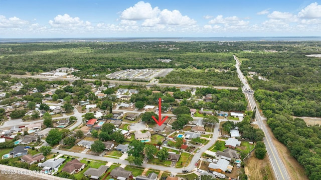 drone / aerial view featuring a forest view and a residential view