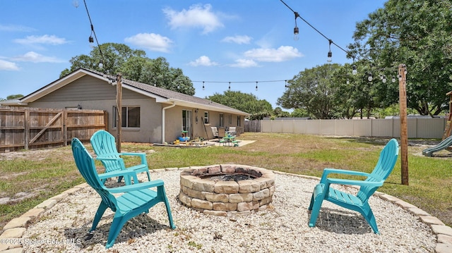view of yard featuring a patio, a fenced backyard, and a fire pit