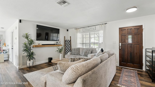 living room featuring baseboards, wood finished floors, and visible vents