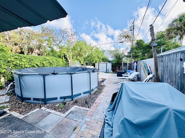 exterior space featuring a storage shed, a fenced in pool, an outbuilding, and a fenced backyard