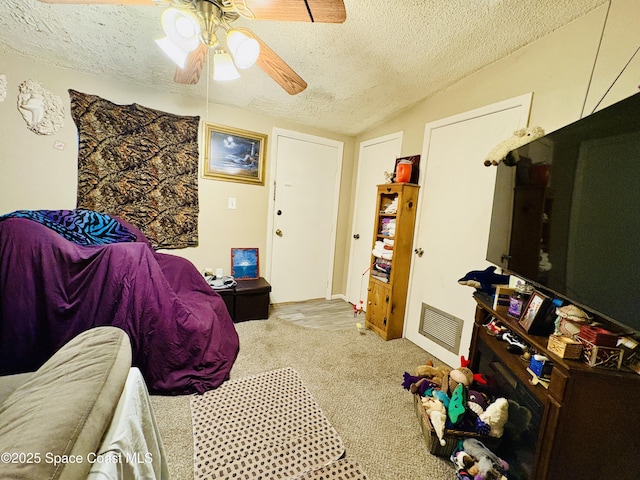carpeted bedroom with a ceiling fan, vaulted ceiling, a textured ceiling, and visible vents