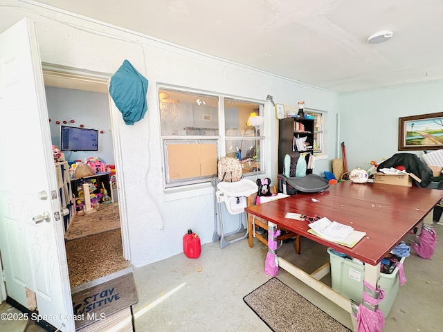 dining room with crown molding and concrete flooring