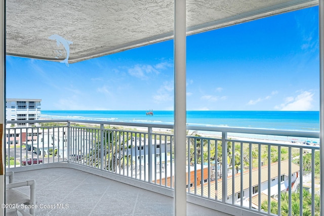 balcony featuring a water view and a view of the beach