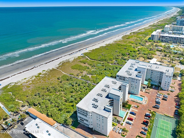 birds eye view of property with a water view and a beach view