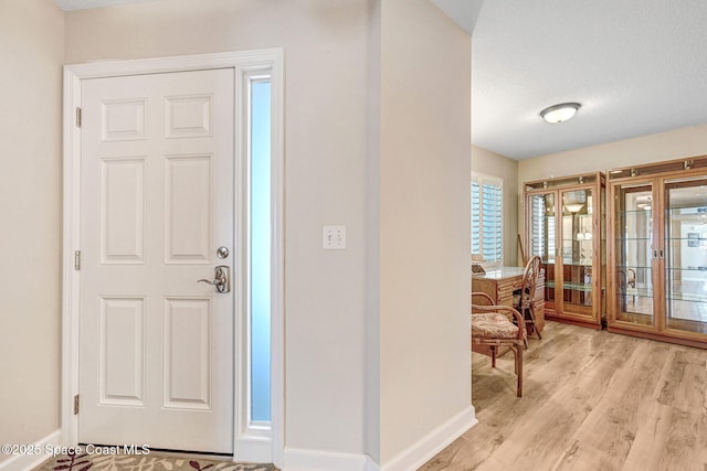 entrance foyer featuring light wood-style floors and baseboards