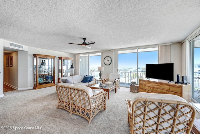 living room with carpet, a textured ceiling, and visible vents