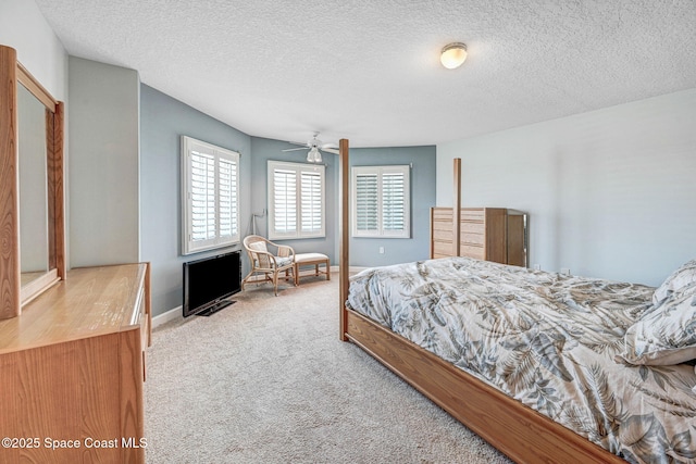 carpeted bedroom with baseboards, a ceiling fan, and a textured ceiling