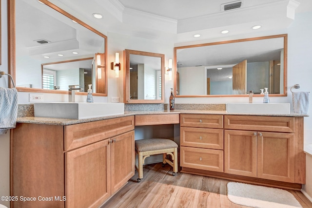 bathroom featuring visible vents, ornamental molding, and wood finished floors