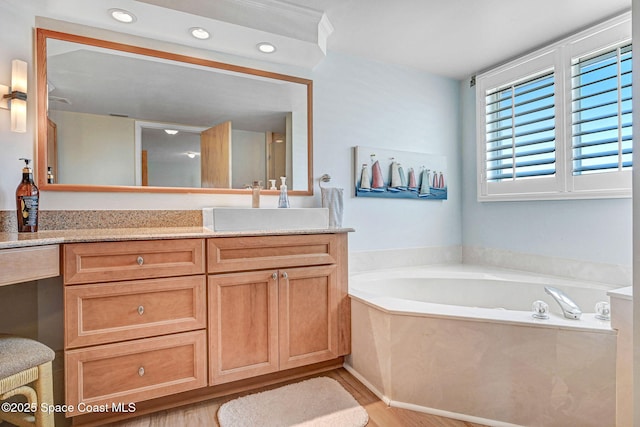 full bath with vanity, recessed lighting, a bath, and wood finished floors