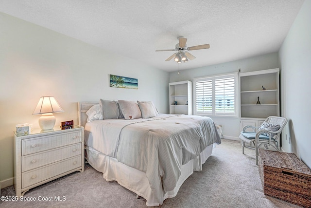 bedroom featuring a ceiling fan, baseboards, light colored carpet, and a textured ceiling