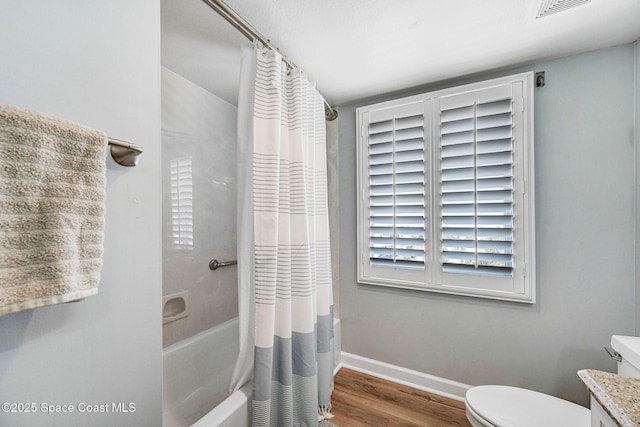full bath with visible vents, wood finished floors, toilet, baseboards, and shower / bathtub combination with curtain