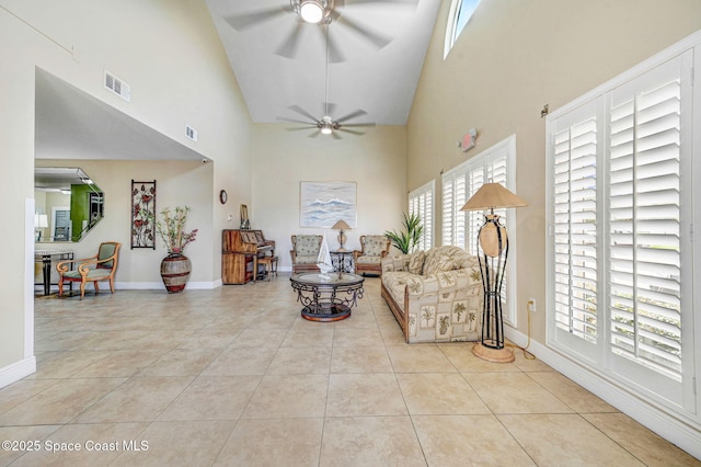 living area with high vaulted ceiling, ceiling fan, tile patterned flooring, and visible vents
