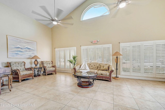 tiled living room with a ceiling fan and high vaulted ceiling
