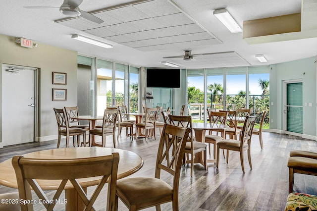 dining area with baseboards, light wood finished floors, ceiling fan, and floor to ceiling windows