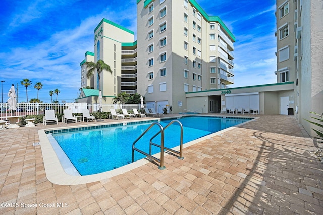 community pool featuring a patio and fence