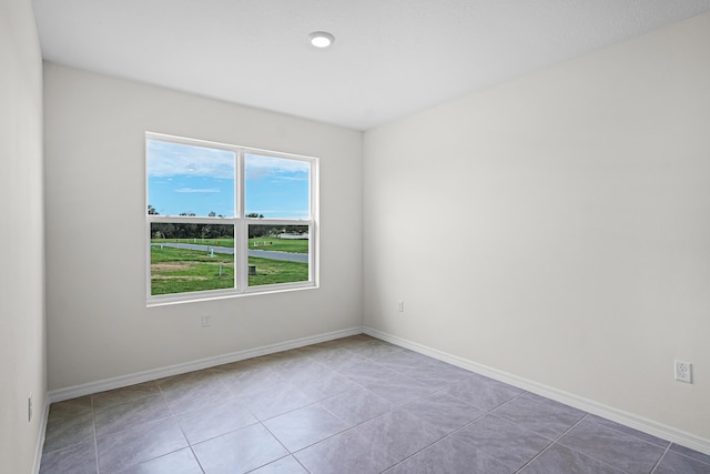 unfurnished room with baseboards and light tile patterned flooring