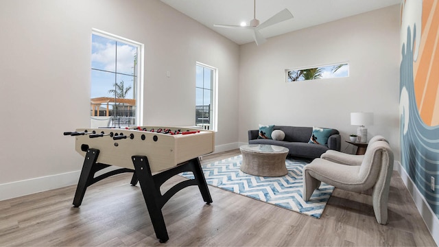 rec room featuring baseboards, a ceiling fan, and wood finished floors