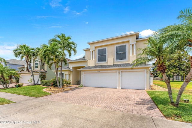 3502 Tipperary Dr, Merritt Island, FL 32953 - view of front of home with decorative driveway, a garage, stucco siding, and a front lawn