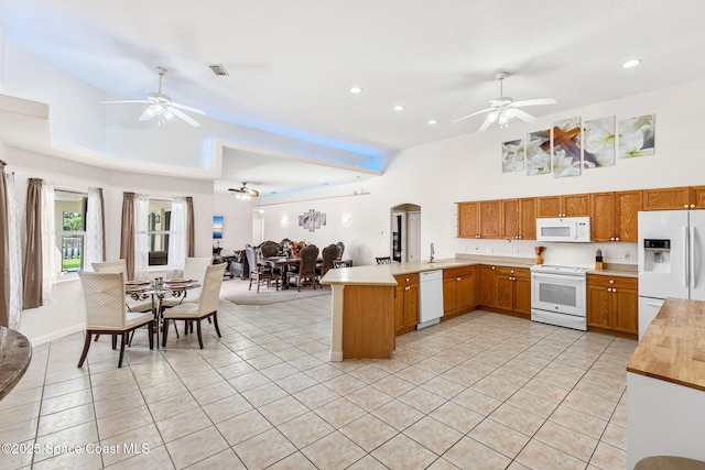 3502 Tipperary Dr, Merritt Island, FL 32953 - kitchen featuring white appliances, ceiling fan, open floor plan, a peninsula, and light tile patterned floors