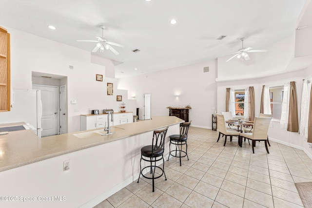 3502 Tipperary Dr, Merritt Island, FL 32953 - kitchen with a ceiling fan, a peninsula, light tile patterned floors, a sink, and vaulted ceiling