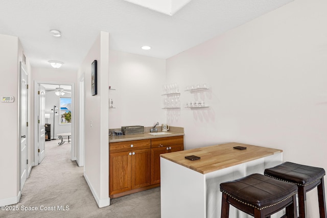 3502 Tipperary Dr, Merritt Island, FL 32953 - bar featuring a sink, light carpet, baseboards, and ceiling fan