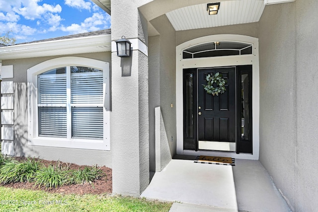 entrance to property featuring stucco siding