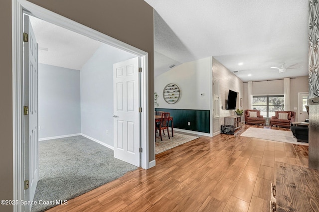foyer with baseboards, a ceiling fan, wood finished floors, and vaulted ceiling