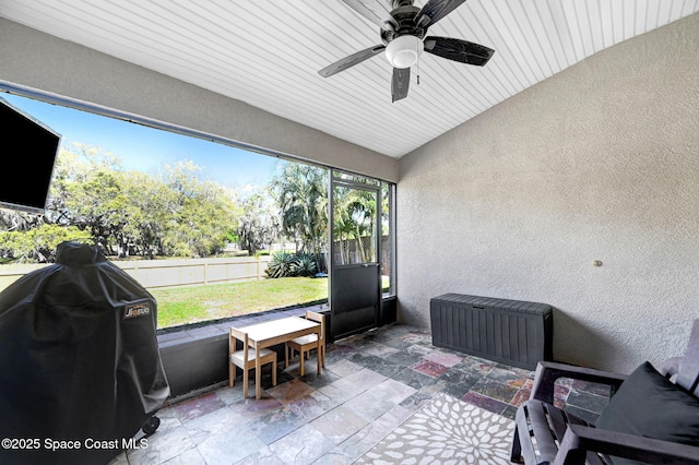 sunroom / solarium with a ceiling fan