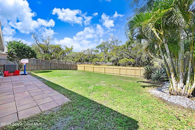 view of yard featuring central AC unit, a fenced backyard, and a patio area