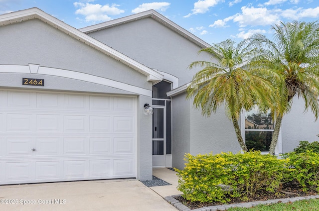 2464 Bayhill Dr, Melbourne, FL 32940 - view of front of property with stucco siding, an attached garage, and concrete driveway