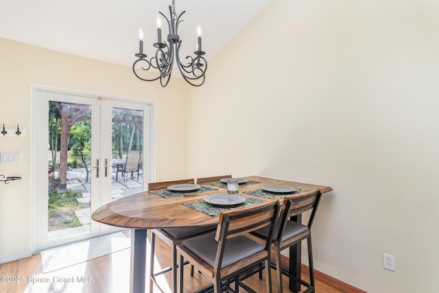 1435 Xavier Ave SE, Palm Bay, FL 32909 - dining area featuring an inviting chandelier, baseboards, french doors, and light wood finished floors