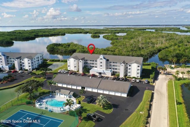 aerial view of apartment complex, a pool, and a nearby body of water