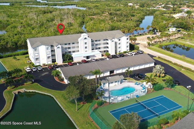 aerial view of a large body of water, apartment complex, and a pool area