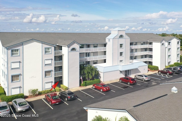 view of apartment building / complex featuring uncovered parking