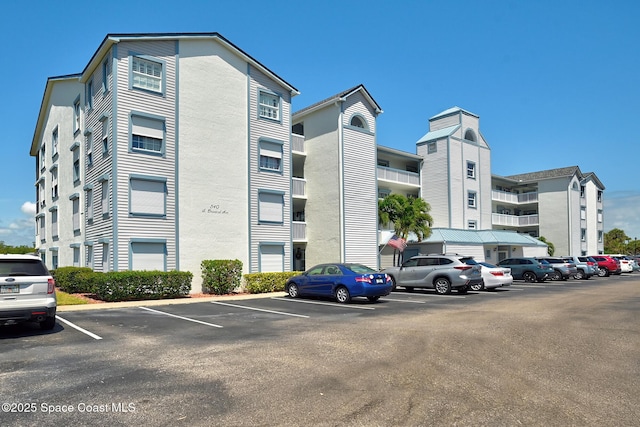 view of apartment building / complex with uncovered parking