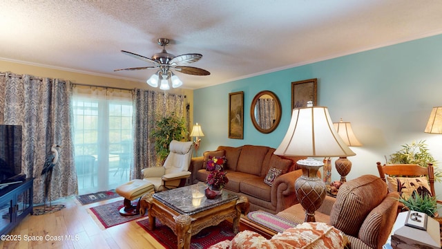 living room with ceiling fan, crown molding, wood finished floors, and a textured ceiling