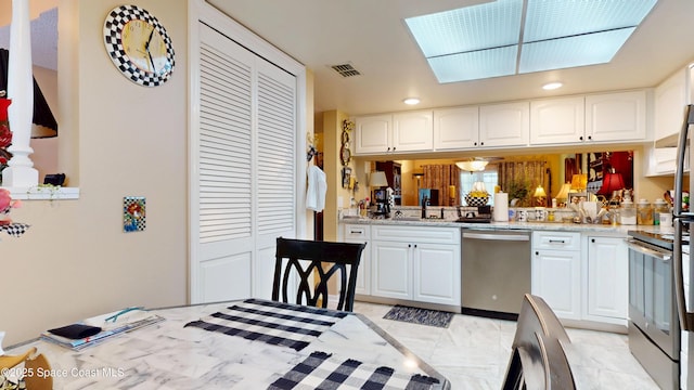 kitchen with stainless steel appliances, a sink, white cabinets, recessed lighting, and light stone countertops