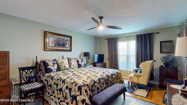 bedroom with wood finished floors, a textured ceiling, and ceiling fan