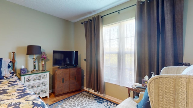 bedroom with wood finished floors and baseboards