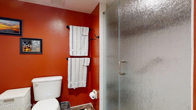 full bath with a stall shower and toilet