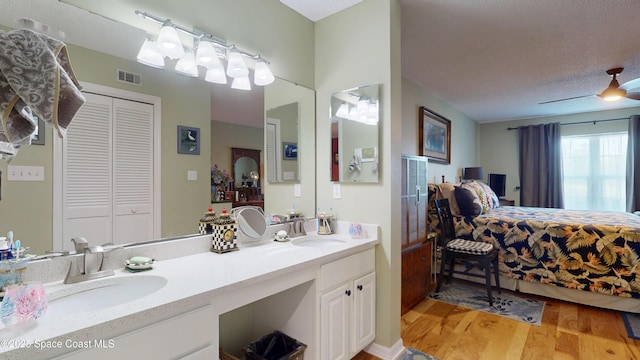 full bath featuring wood finished floors, a closet, and double vanity