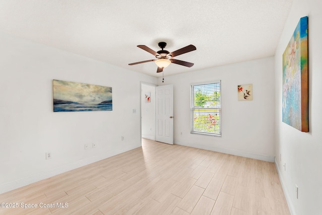 empty room with ceiling fan, baseboards, and light wood finished floors
