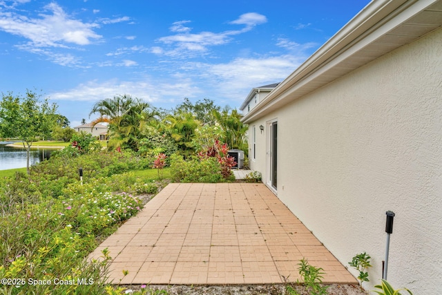 view of patio with central air condition unit and a water view