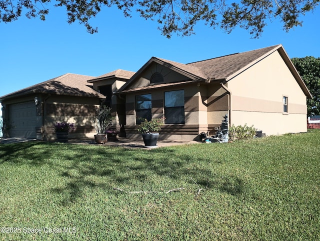 view of front of property featuring stucco siding, a shingled roof, a front lawn, and a garage