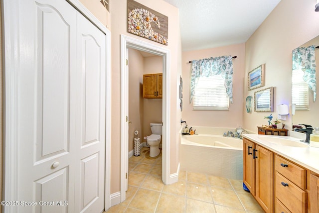 bathroom featuring a garden tub, tile patterned flooring, vanity, baseboards, and toilet