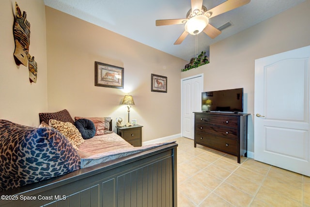 bedroom with visible vents, a closet, light tile patterned flooring, baseboards, and ceiling fan