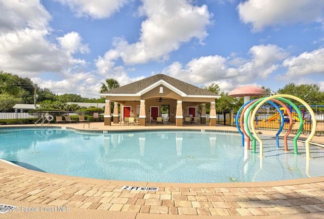 pool with fence, a ceiling fan, a patio, and a water play area