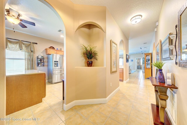 hallway featuring light tile patterned floors, a wealth of natural light, and visible vents