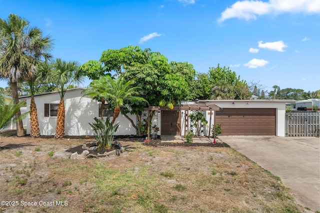 107 Algonquin Ter, Indian Harbour Beach, FL 32937 - view of front of house featuring fence, concrete driveway, a garage, and stucco siding